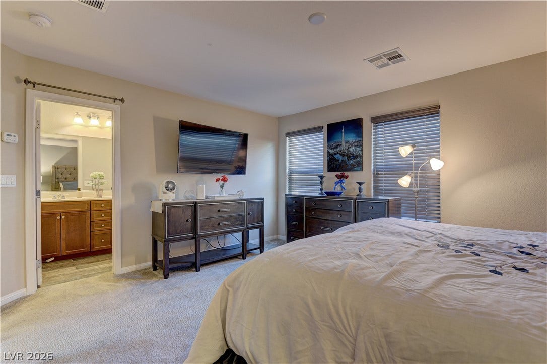 4650 Ranch House Road, #14, North Las Vegas, NV 89031 Plush carpeting and large windows define this comfortable primary bedroom featuring an attached bath.