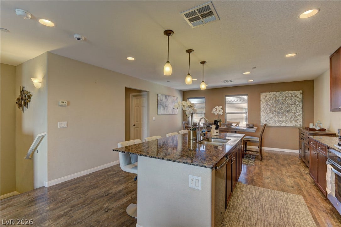 4650 Ranch House Road, #14, North Las Vegas, NV 89031 Gleaming stone countertops and warm wood floors define this open culinary and dining space.