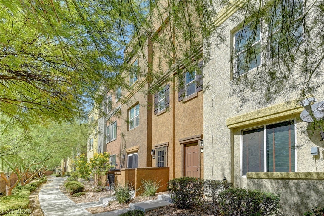 4650 Ranch House Road, #14, North Las Vegas, NV 89031 A paved walkway winds past the classic stucco facades of these multi-level townhomes.
