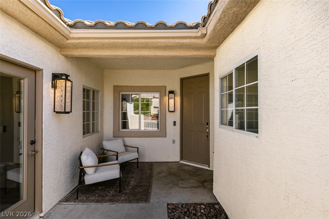 2897 Sunlit Glade Avenue, Henderson, NV 89074 An inviting gated courtyard features textured stucco walls under a classic tile roofline.