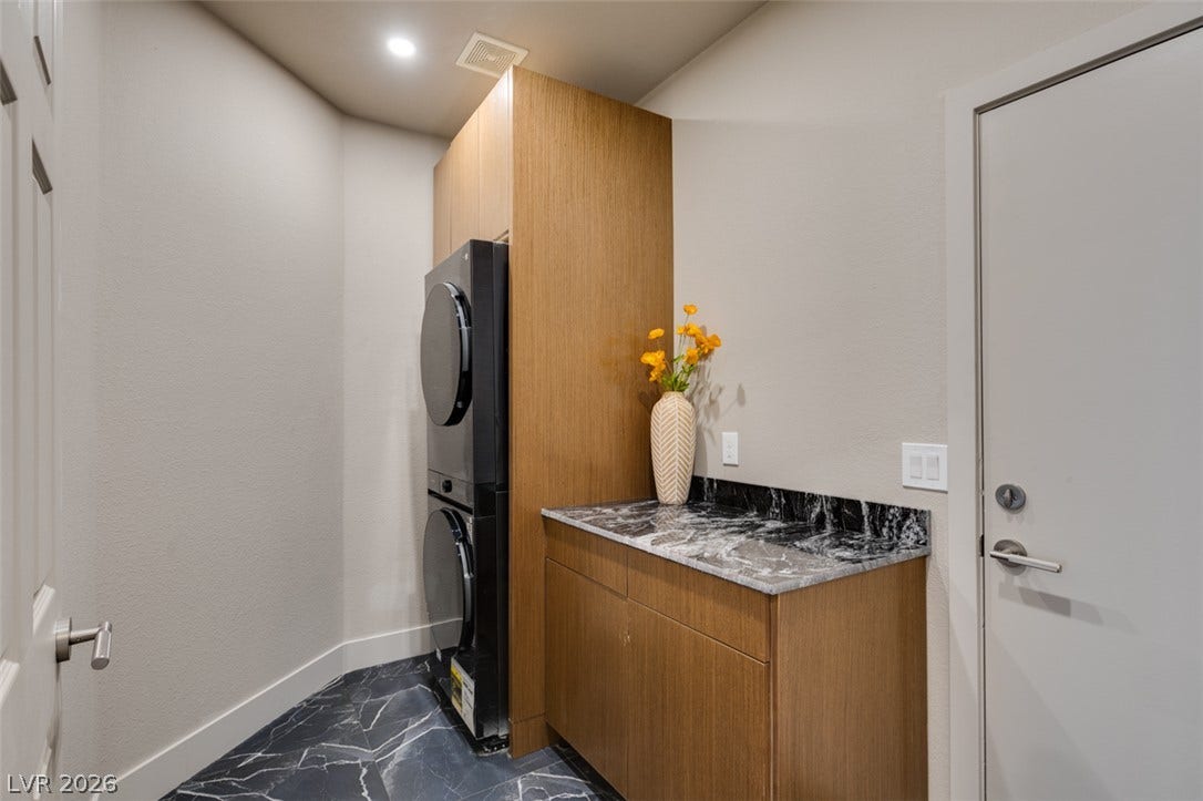 2897 Sunlit Glade Avenue, Henderson, NV 89074 Striking dark tiled flooring and sleek modern cabinetry anchor this functional laundry space.