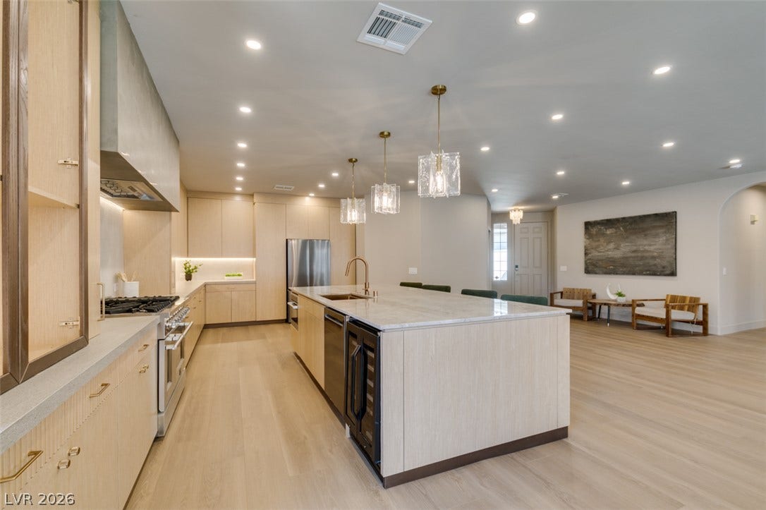 2897 Sunlit Glade Avenue, Henderson, NV 89074 Gleaming wood floors anchor an airy kitchen flowing directly into adjacent living spaces.