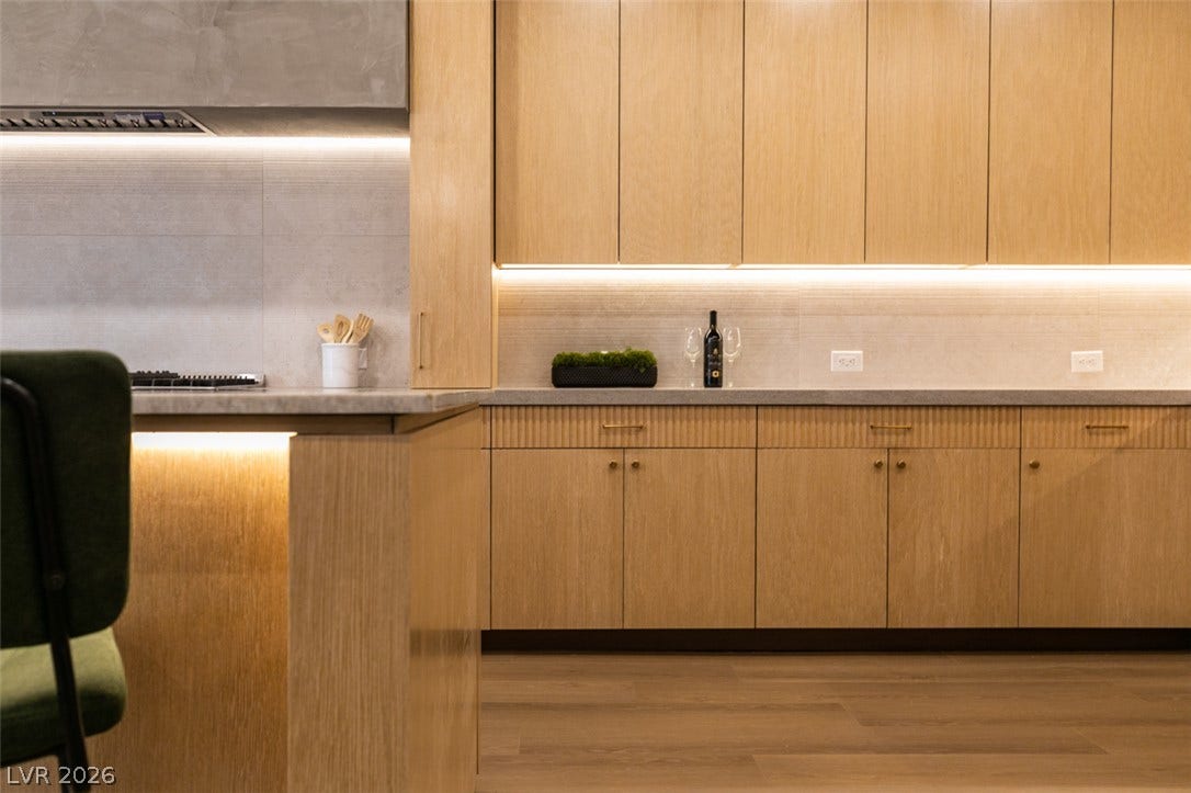 2897 Sunlit Glade Avenue, Henderson, NV 89074 Warm wood cabinetry and integrated under-cabinet lighting define this refined modern kitchen space.