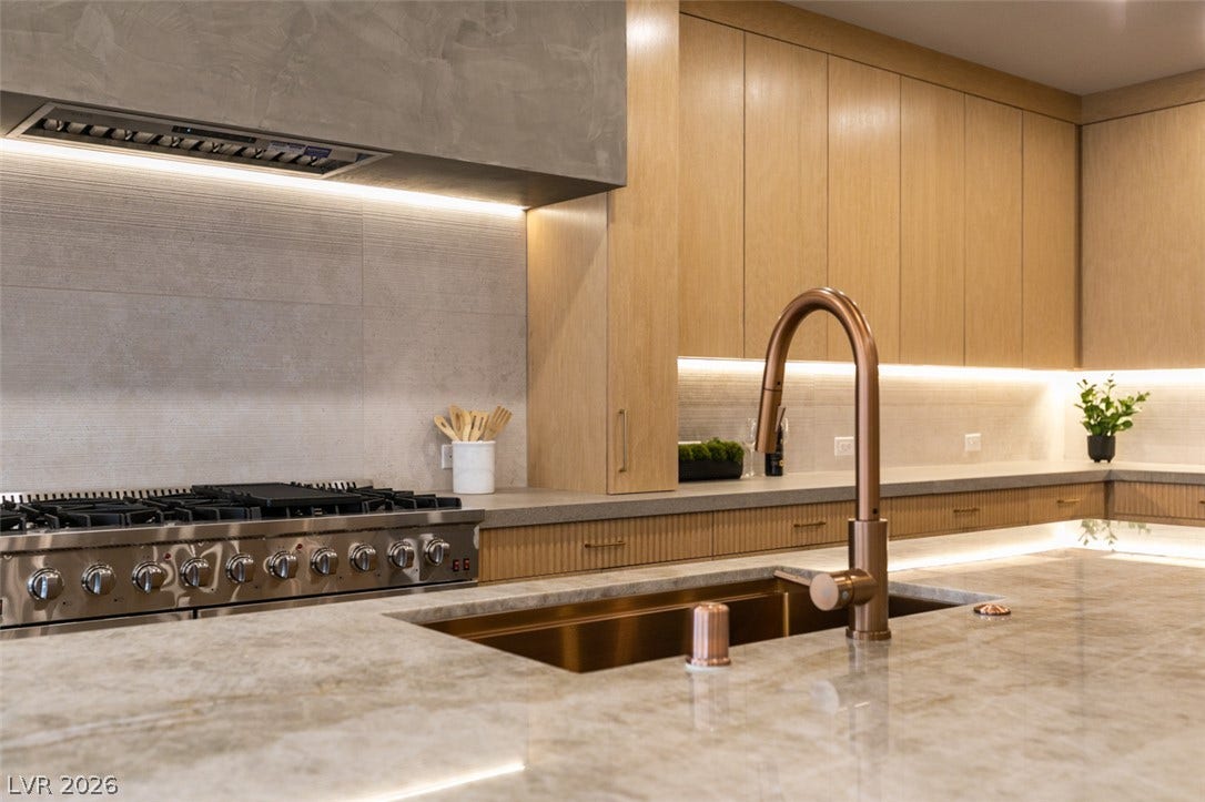 2897 Sunlit Glade Avenue, Henderson, NV 89074 Warm wood cabinetry pairs with stone countertops and high-end built-in appliances.