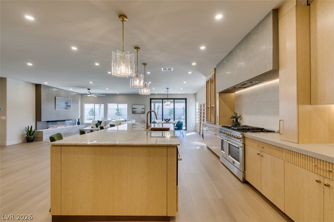 2897 Sunlit Glade Avenue, Henderson, NV 89074 Gleaming wood floors anchor an airy gourmet kitchen boasting a massive stone-topped prep island.