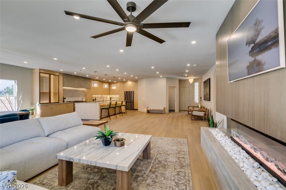 2897 Sunlit Glade Avenue, Henderson, NV 89074 An open floorplan seamlessly connects the living space to the kitchen over wood flooring.