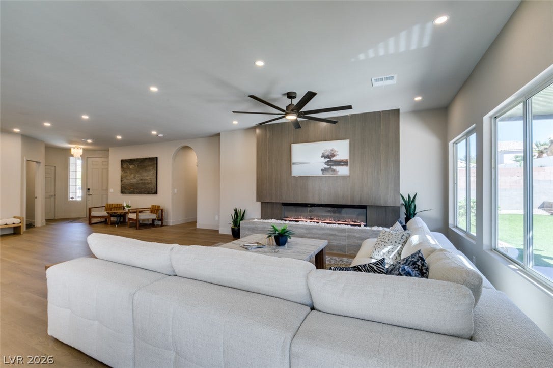 2897 Sunlit Glade Avenue, Henderson, NV 89074 An open floor plan connects the living room with large windows to the spacious entryway.