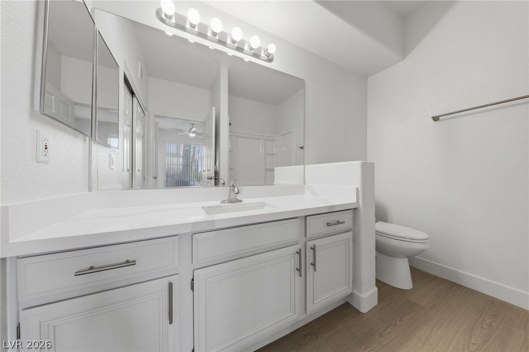 7139 S Durango Drive, #110, Las Vegas, NV 89113 An expansive mirror pairs with a generous single vanity over clean wood-style flooring.