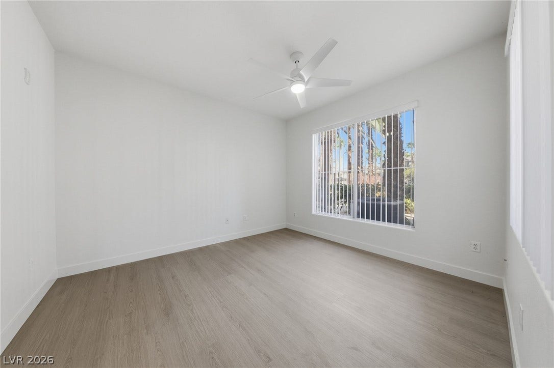 7139 S Durango Drive, #110, Las Vegas, NV 89113 Smooth wood-look flooring and a large window framing palm trees define this versatile space.