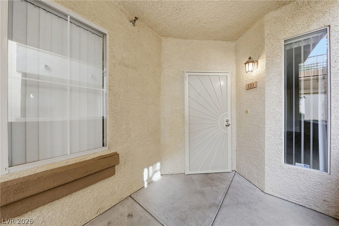 7139 S Durango Drive, #110, Las Vegas, NV 89113 An inviting covered entryway features textured stucco walls and concrete flooring.