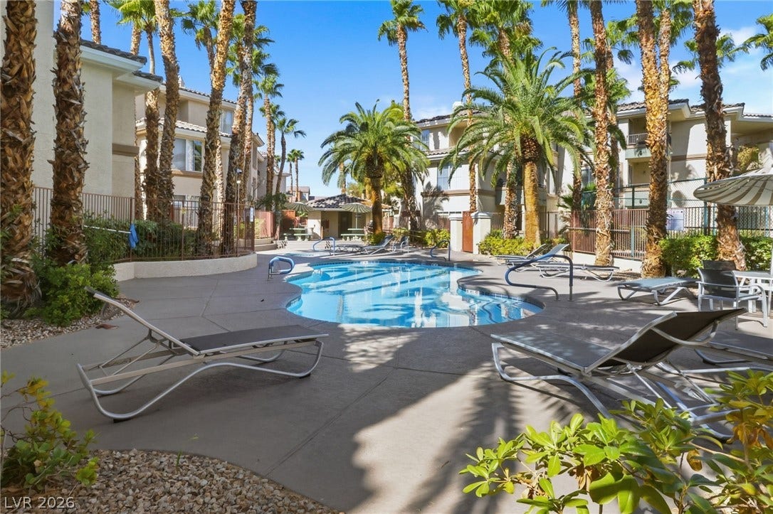 7139 S Durango Drive, #110, Las Vegas, NV 89113 Towering palm trees frame a sparkling community swimming pool surrounded by a spacious sun deck.