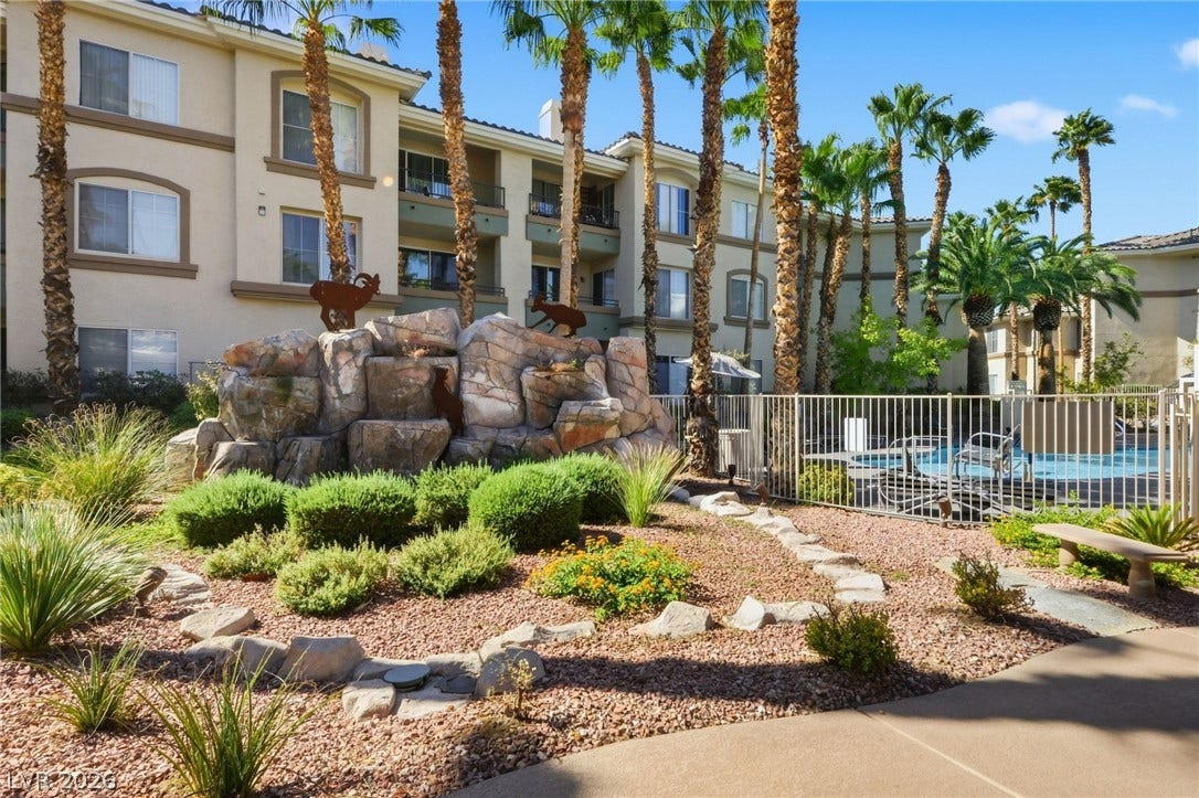 7139 S Durango Drive, #110, Las Vegas, NV 89113 Lush desert landscaping and a resort-style pool area surround the multi-story residential building.