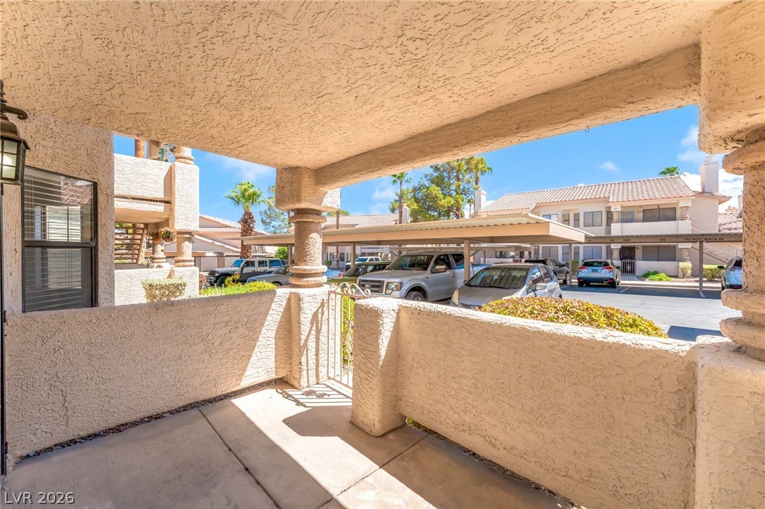 1017 Falconhead Lane, #102, Las Vegas, NV 89128 Concrete pillars frame a private, sheltered patio looking out onto the neighborhood parking area.