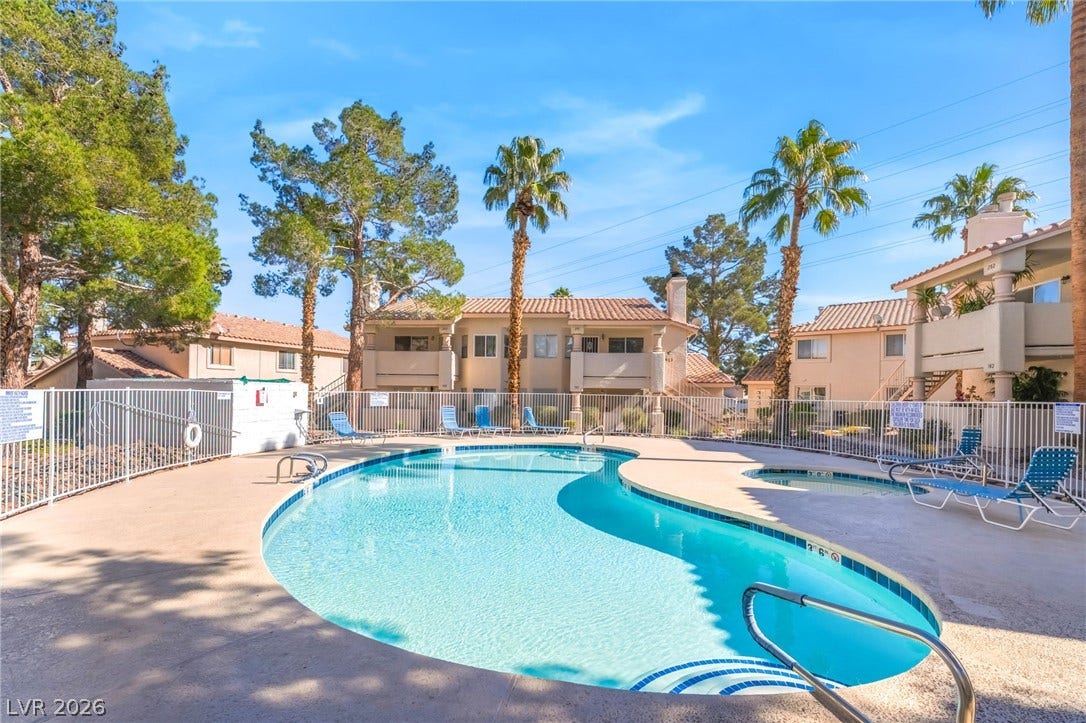 1017 Falconhead Lane, #102, Las Vegas, NV 89128 An inviting swimming pool and spa are surrounded by towering palm trees.