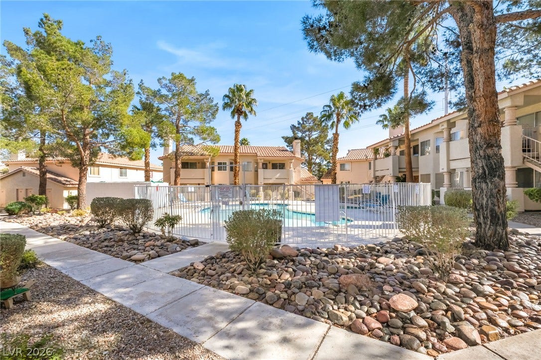 1017 Falconhead Lane, #102, Las Vegas, NV 89128 Mature trees and neat rock landscaping frame the gated sparkling community pool.