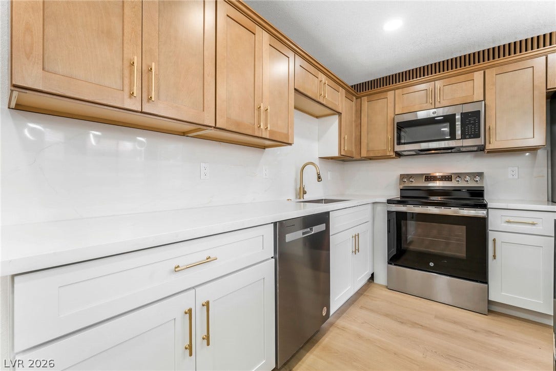 1017 Falconhead Lane, #102, Las Vegas, NV 89128 Gleaming stone countertops and modern stainless steel appliances anchor this beautifully updated kitchen.