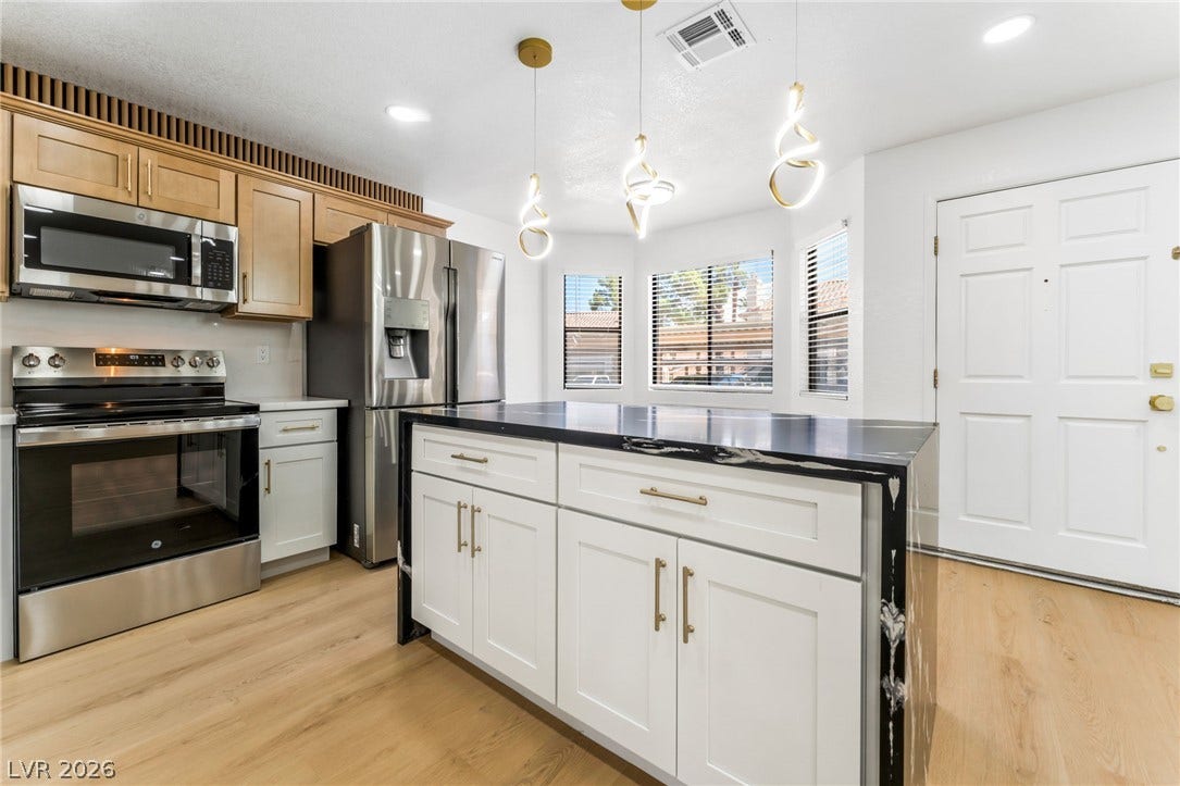 1017 Falconhead Lane, #102, Las Vegas, NV 89128 Rich hardwood flooring complements the sleek stone-topped island in this modern culinary space.