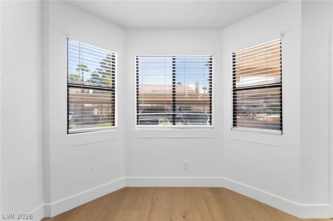 1017 Falconhead Lane, #102, Las Vegas, NV 89128 Natural light streams through a classic bay window onto warm wood-plank flooring.