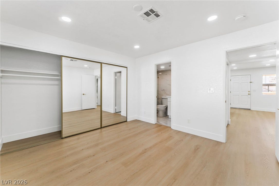 1017 Falconhead Lane, #102, Las Vegas, NV 89128 Gleaming wood floors pair with mirrored closets in a thoughtfully laid out master bedroom.