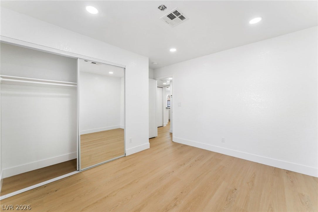 1017 Falconhead Lane, #102, Las Vegas, NV 89128 Recessed lighting and warm wood-style flooring create a bright, inviting atmosphere in this bedroom.