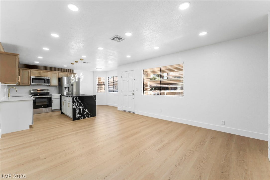 1017 Falconhead Lane, #102, Las Vegas, NV 89128 Smooth wood floors anchor this open concept layout under a network of recessed lights.