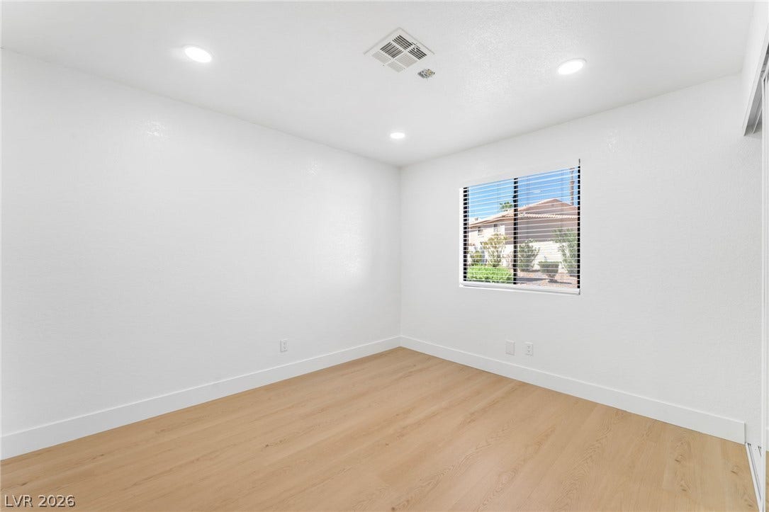 1017 Falconhead Lane, #102, Las Vegas, NV 89128 Recessed lighting and wide-plank wood flooring define this versatile, light-filled bedroom space.