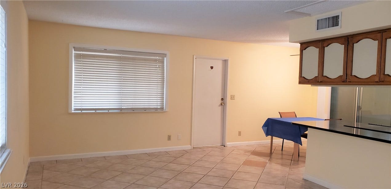 Tiled flooring and a raised breakfast bar define this open living and dining layout.