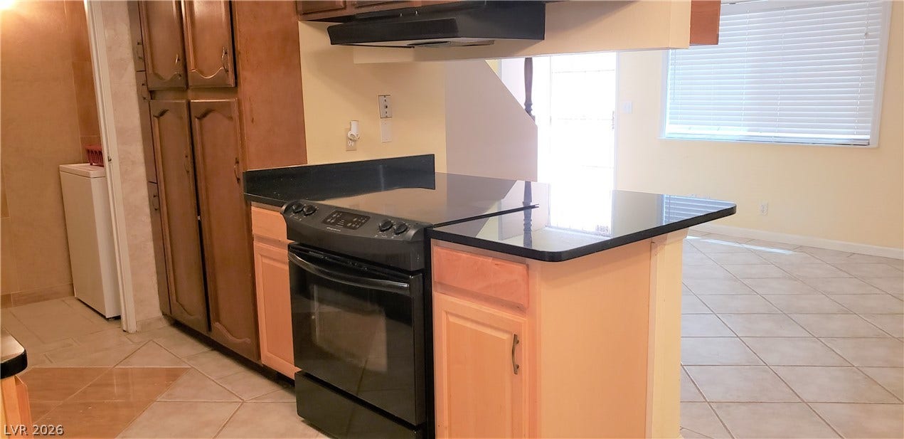 Gleaming stone countertops integrate seamlessly into an open kitchen layout with durable tile flooring.