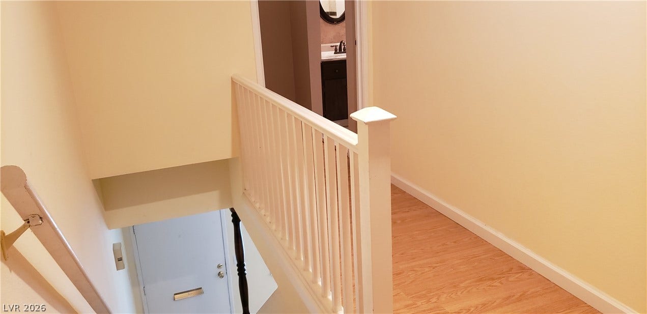 Gleaming hardwood floors and a crisp white banister define this upper-level hallway landing.