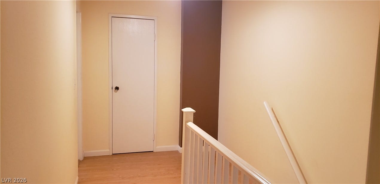 Smooth wood floors and neutral walls define this functional hallway space.