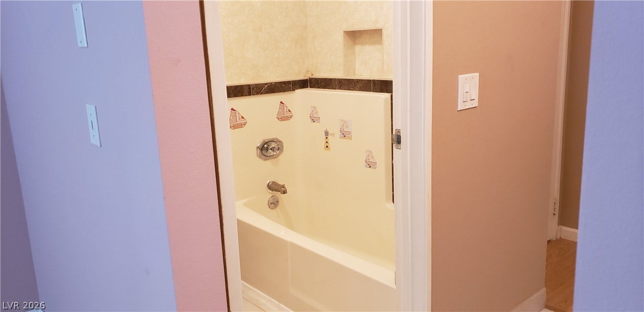 A classic tiled shower and tub setup stands ready in this functional bathroom.