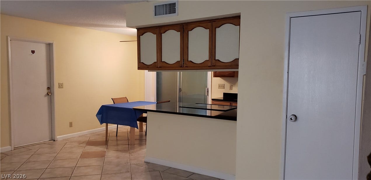 Tiled flooring stretches through the open living space towards the functional breakfast bar.