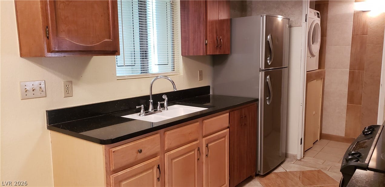 Functional design highlights this kitchen featuring granite counters and durable tile flooring.