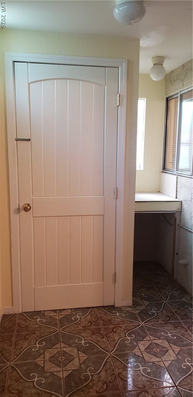 Glossy patterned tile floors and bright walls create a clean entry space.