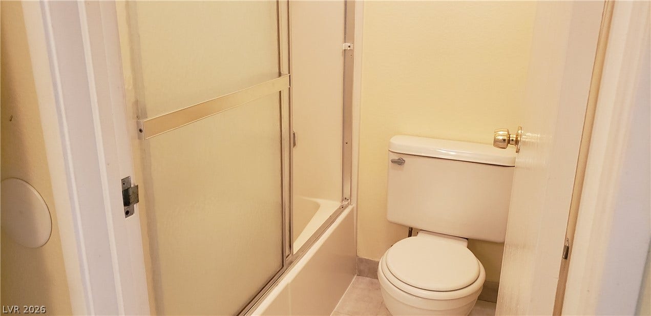 Functional bathroom layout features a combined tub and shower enclosed by sliding glass doors.