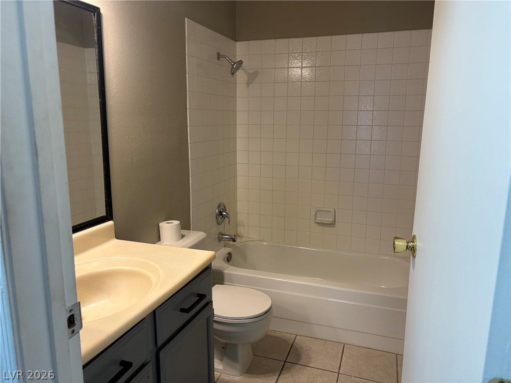 A classic bathtub and tile surround complement the vanity in this functional bathroom.