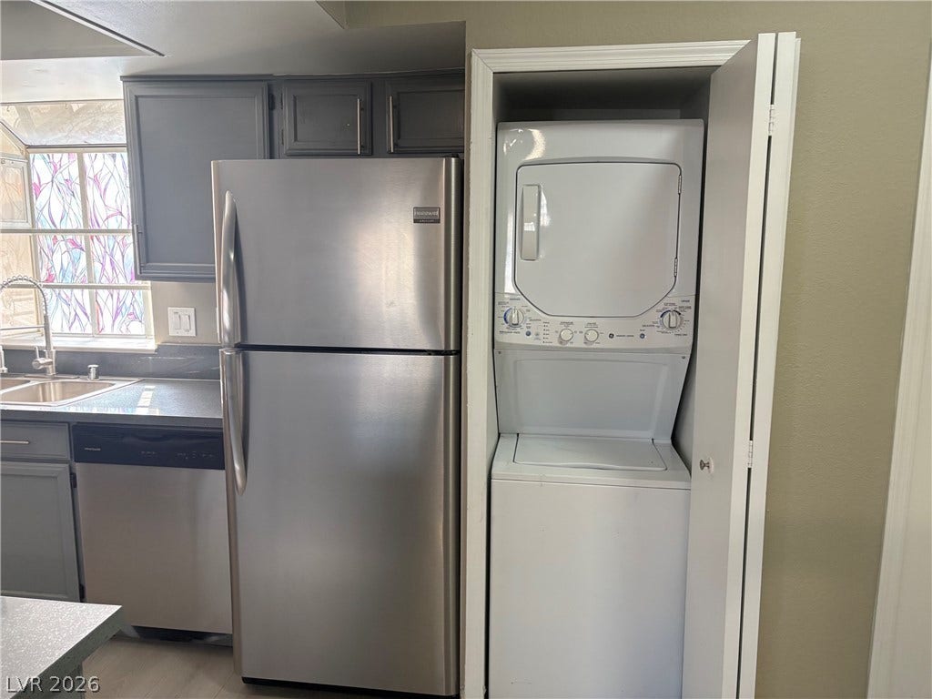 A tucked-away closet neatly houses a stacked washer and dryer unit beside the kitchen.
