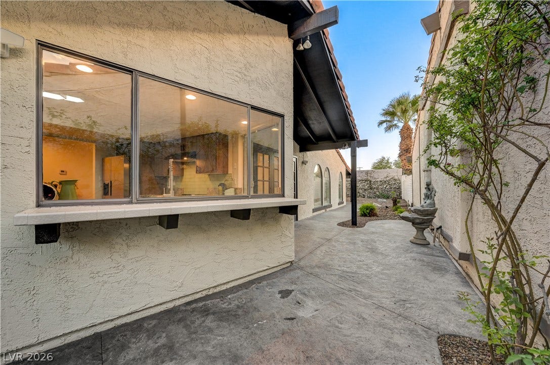 3005 Plaza De Rosa, Las Vegas, NV 89102 A spacious concrete patio area winds alongside the stucco exterior under deep roof overhangs.