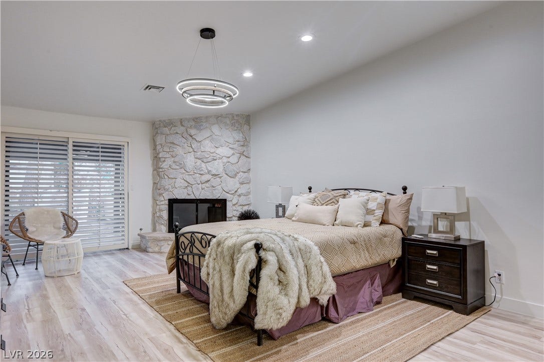 3005 Plaza De Rosa, Las Vegas, NV 89102 An inviting stone fireplace provides a cozy focal point on light wood flooring.