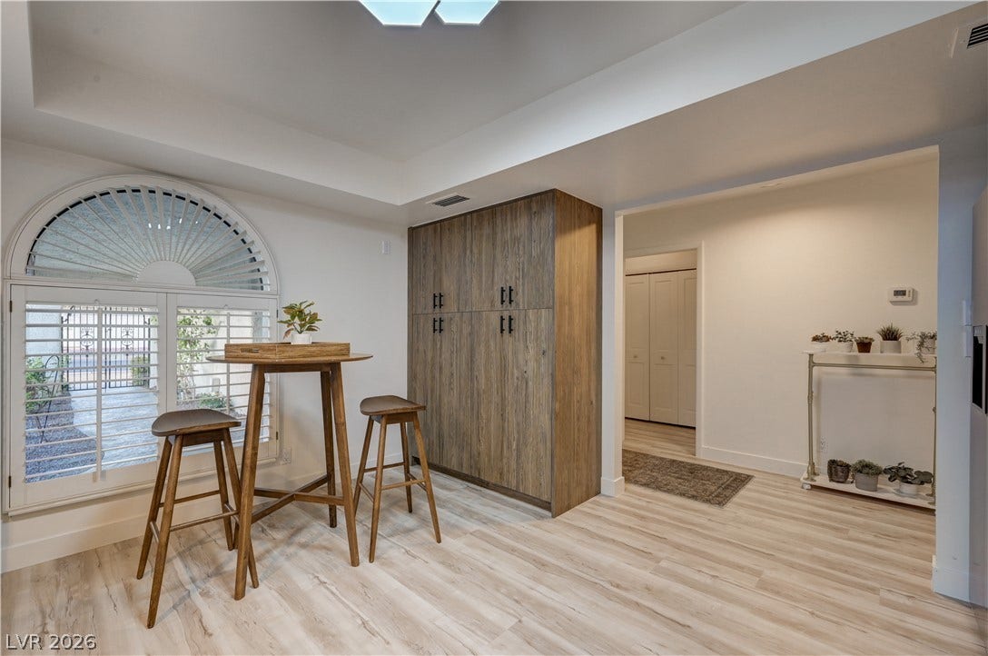 3005 Plaza De Rosa, Las Vegas, NV 89102 A spacious dining area showcases light wood flooring and custom built-in cabinetry beside a large arched window.