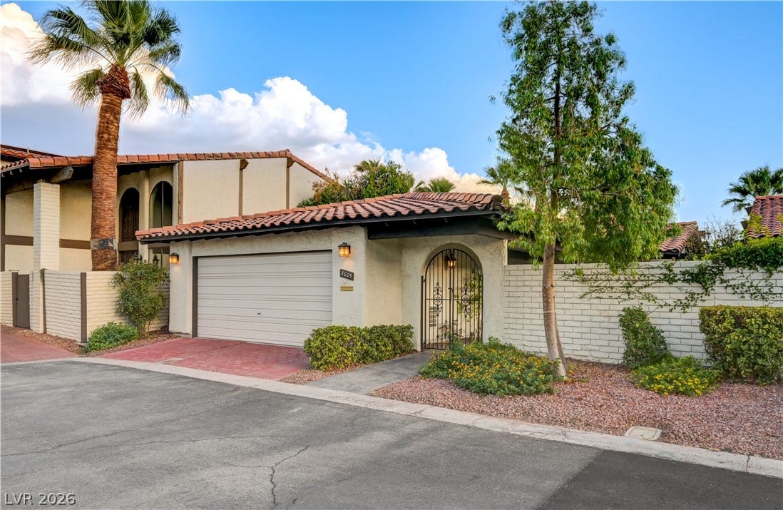 3005 Plaza De Rosa, Las Vegas, NV 89102 Spanish tile roofing and an arched wrought iron gate create an inviting entrance.