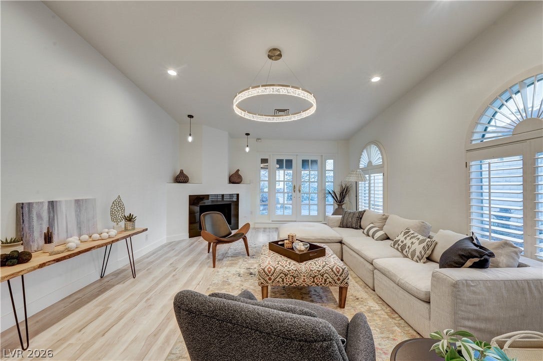 3005 Plaza De Rosa, Las Vegas, NV 89102 Arched windows and a fireplace elevate this light-filled room with light wood flooring.