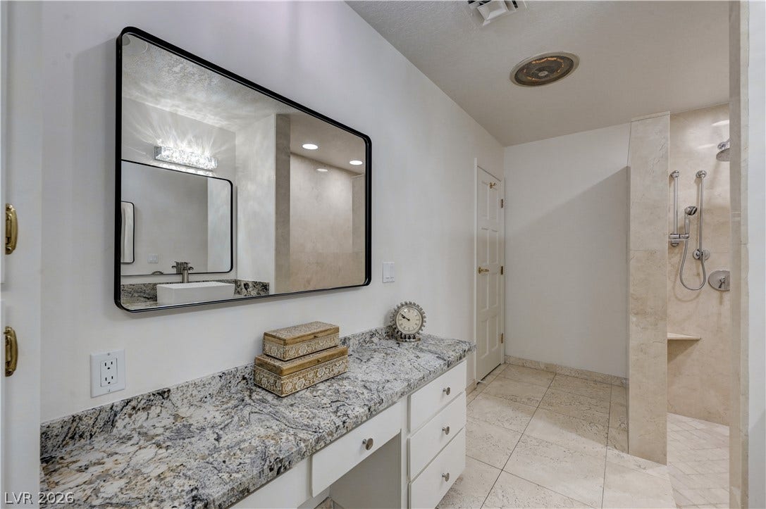 3005 Plaza De Rosa, Las Vegas, NV 89102 Polished stone counters and a walk-in tile shower define this refined washroom.