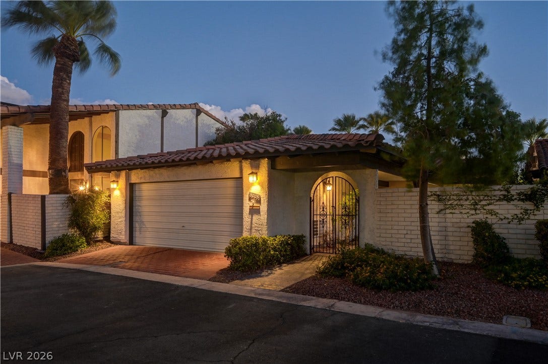 3005 Plaza De Rosa, Las Vegas, NV 89102 A gated entry path and two-car garage stand beneath a classic tile roof.