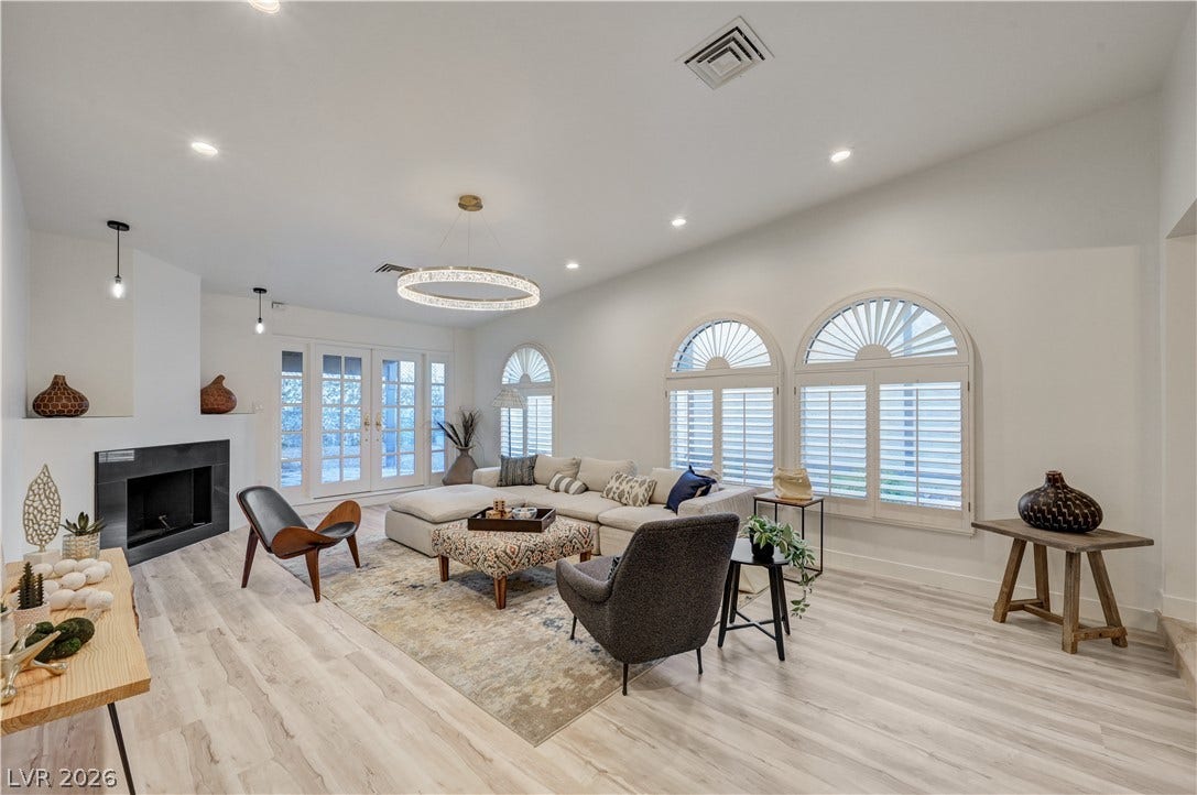 3005 Plaza De Rosa, Las Vegas, NV 89102 Vaulted ceilings and arched windows elevate this welcoming living space centered around a sleek fireplace.