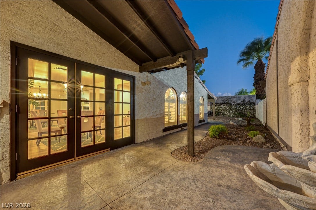 3005 Plaza De Rosa, Las Vegas, NV 89102 A sheltered concrete patio features French doors opening into the warm interior spaces.