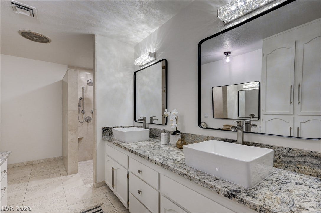 3005 Plaza De Rosa, Las Vegas, NV 89102 Polished granite countertops and dual vessel sinks create a refined, modern bathroom design.
