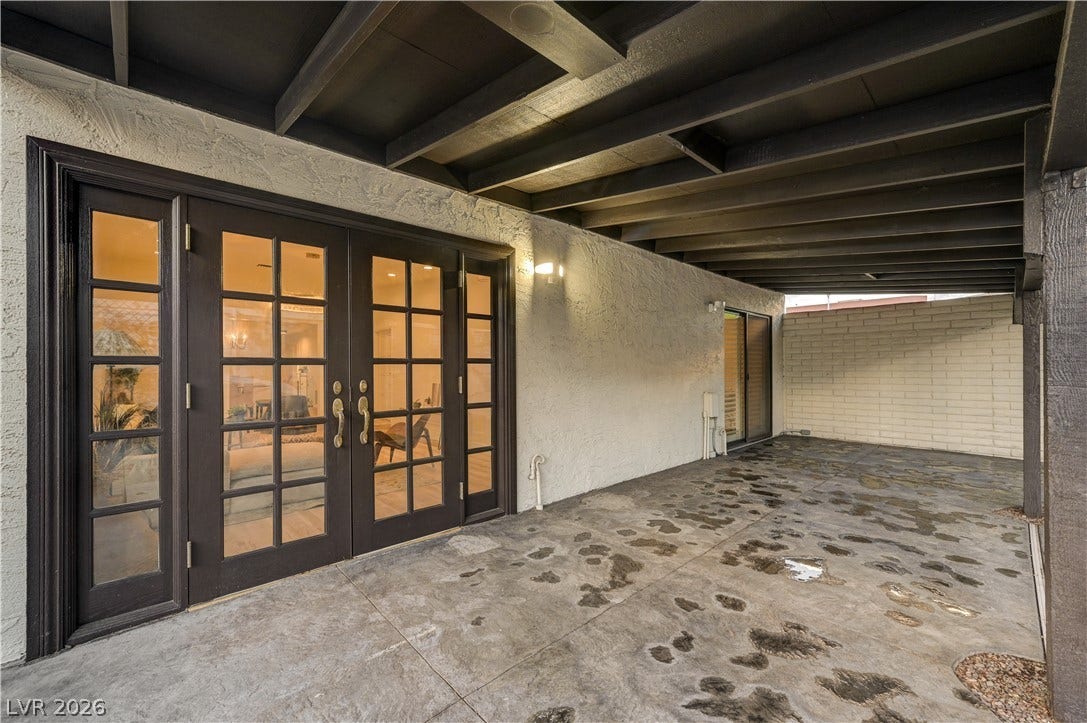 3005 Plaza De Rosa, Las Vegas, NV 89102 Double French doors open to a sheltered patio with stained concrete flooring.