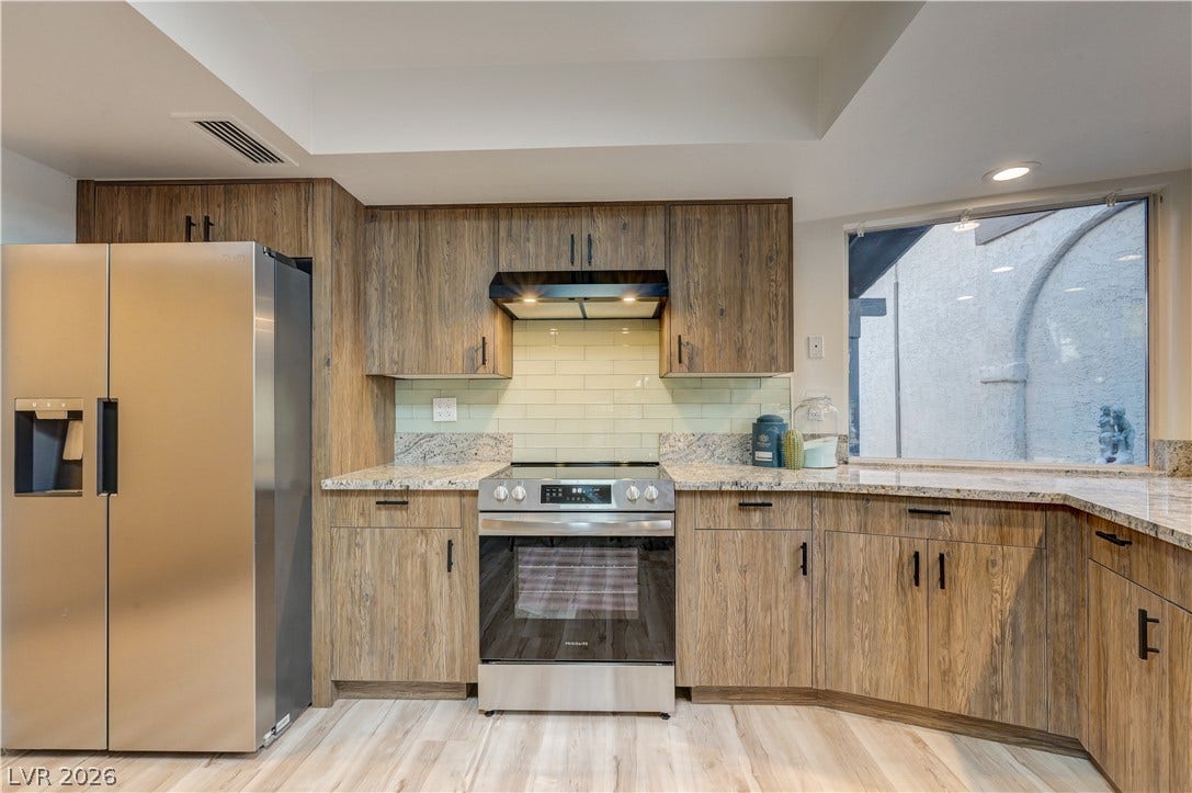 3005 Plaza De Rosa, Las Vegas, NV 89102 Rich wood cabinetry contrasts beautifully with granite countertops and modern stainless steel appliances.