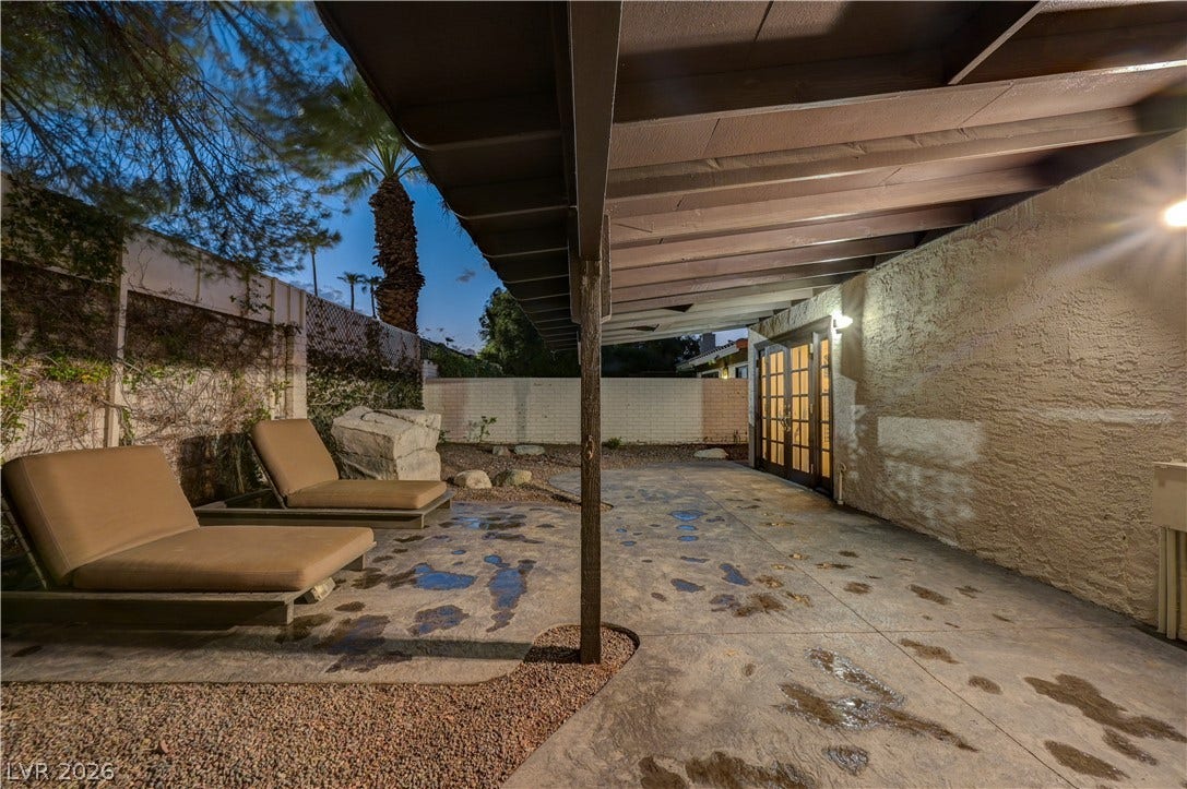 3005 Plaza De Rosa, Las Vegas, NV 89102 An inviting covered patio features flagstone-patterned concrete flooring and robust wood ceiling beams.